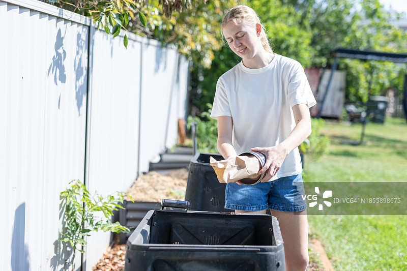 使用花园堆肥箱的年轻女人图片素材