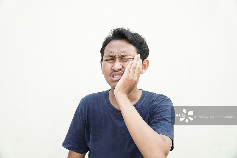 亚洲少年因牙齿敏感而牙痛图片素材