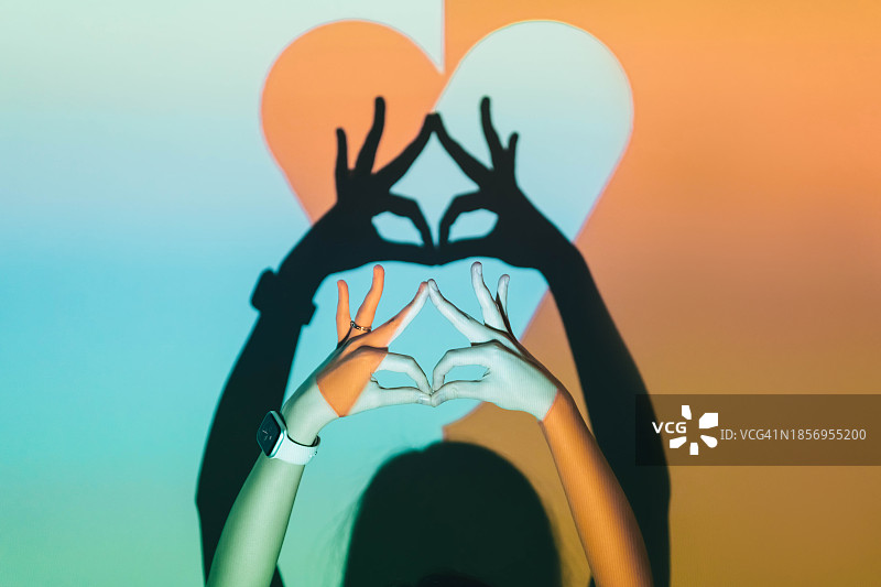 女人在双色心形背景上展示眼睛图片素材