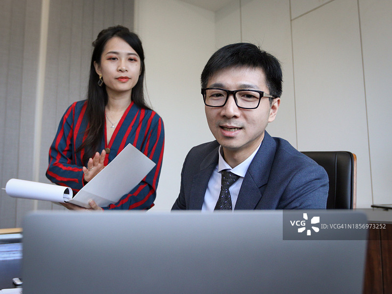 亚洲男主管与亚洲女秘书讨论公务图片素材