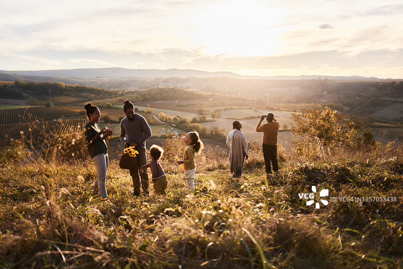 黑人一家人在日落时分在山坡上玩耍图片素材