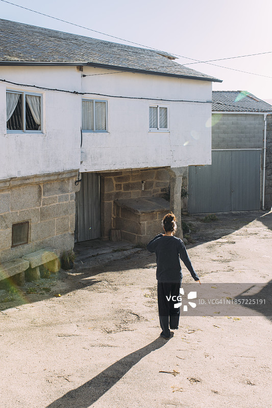 在村庄里行走的年轻女子（背影）图片素材