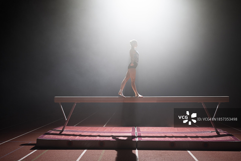 在平衡木上表演的体操女运动员图片素材