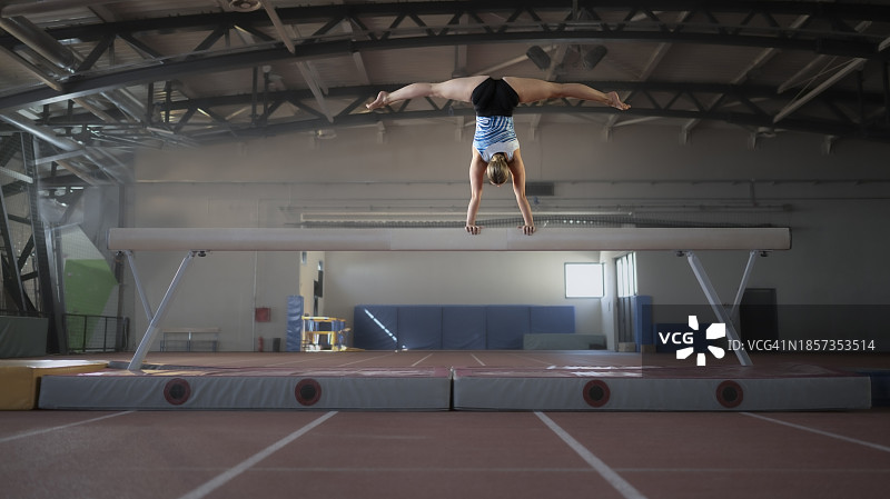 体操女运动员在平衡木上练习图片素材