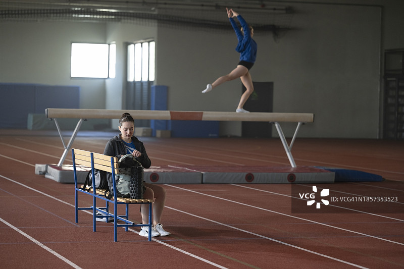 坐在长凳上的体操女运动员图片素材