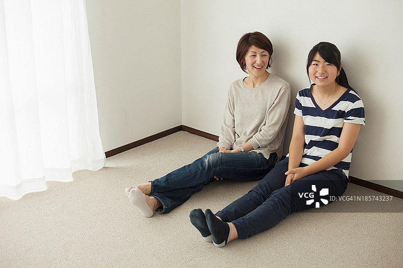 妈妈和少女坐在地板上，肖像图片素材