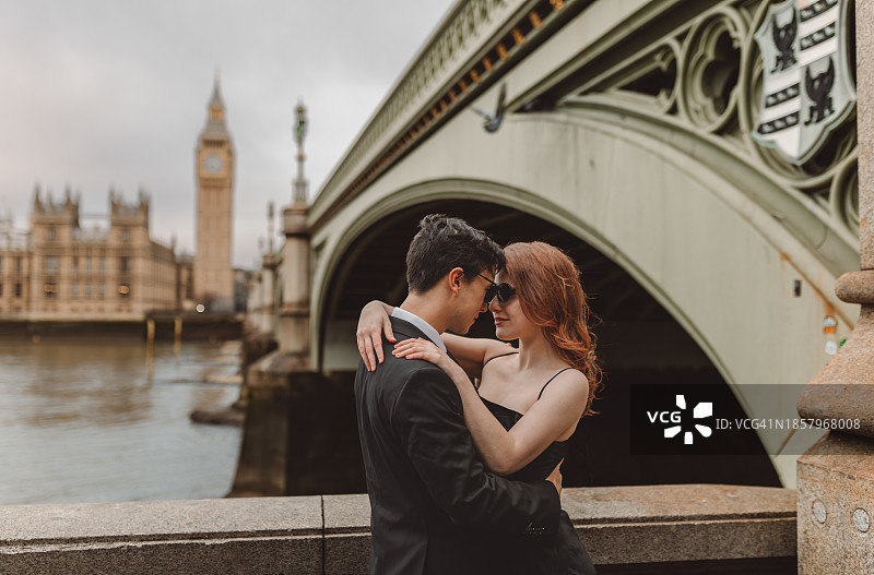快乐的年轻情侣在英国伦敦标志性街道上亲吻并享受浪漫假期，背景是大本钟图片素材