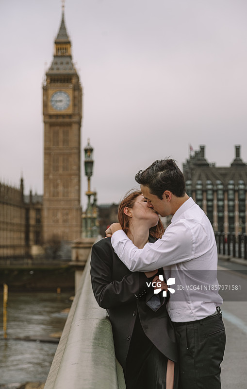 快乐的年轻情侣在英国伦敦标志性街道上亲吻并享受浪漫假期，背景是大本钟图片素材