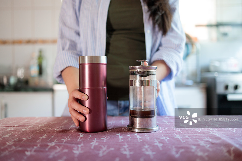 环保生活方式：拉丁女人用咖啡壶煮咖啡图片素材