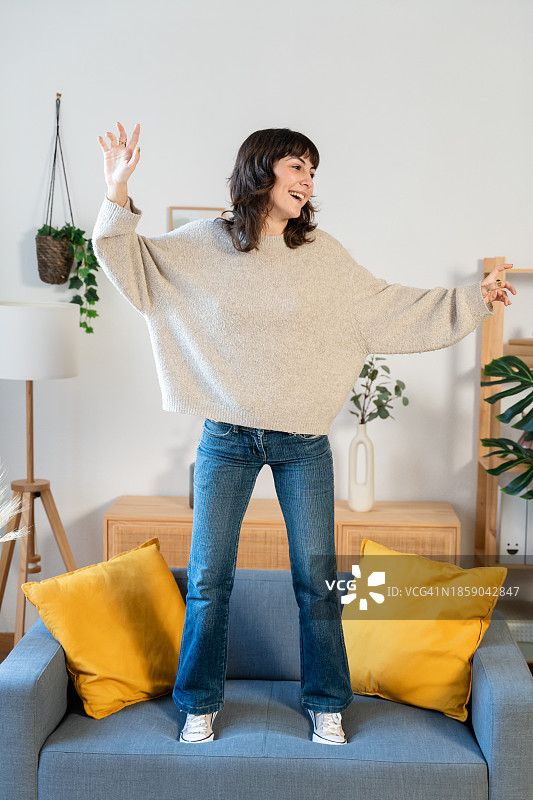 在家中沙发上手势交谈的开朗年轻女人图片素材