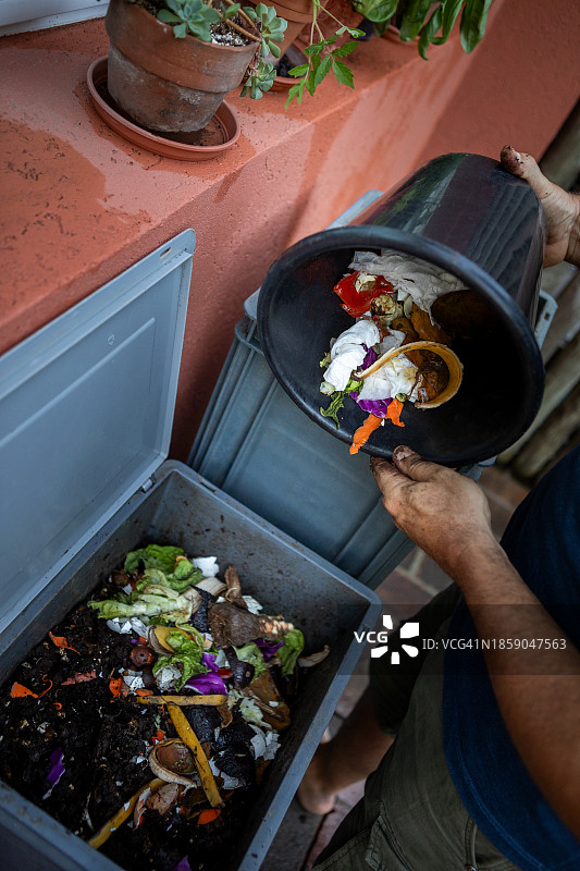 男人在家用堆肥器中堆放有机物图片素材