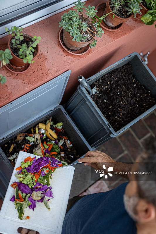 男人在家用堆肥器中堆放有机物图片素材
