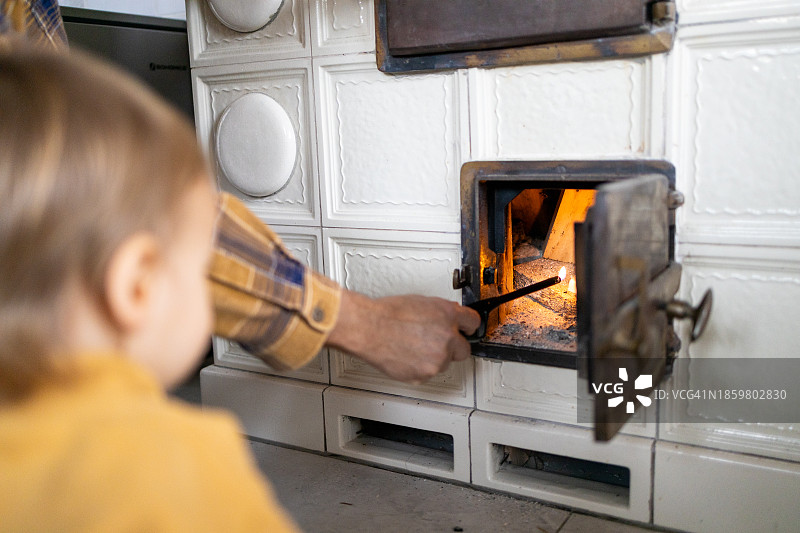 男人在家用打火机在壁炉里点火图片素材