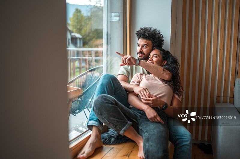时尚的多种族情侣在窗边放松身心图片素材