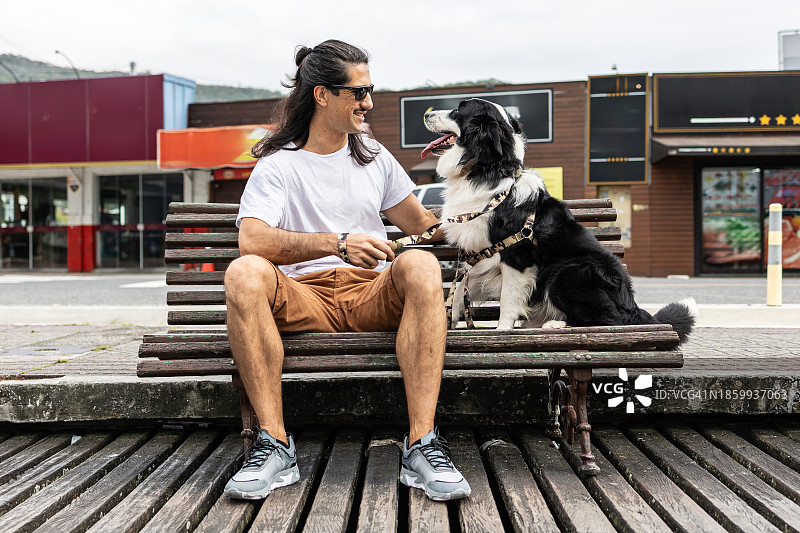 男人和狗在木制长椅上图片素材