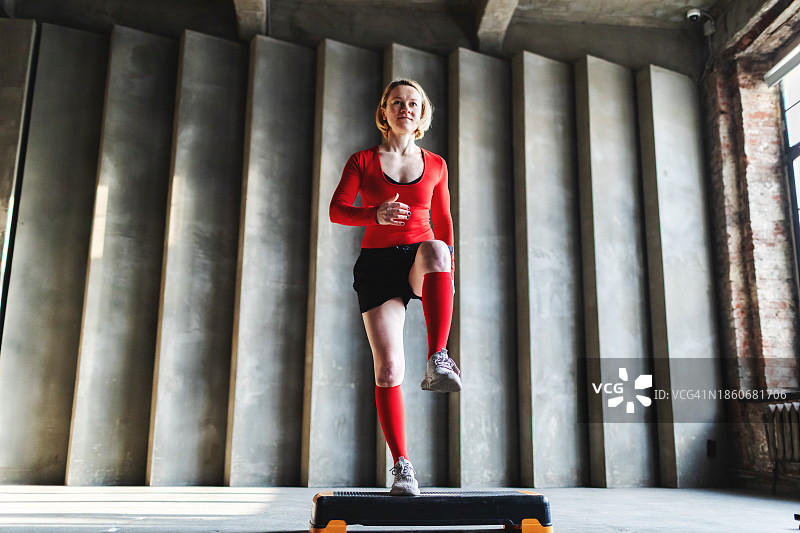 年轻女人在健身房用踏步机训练图片素材