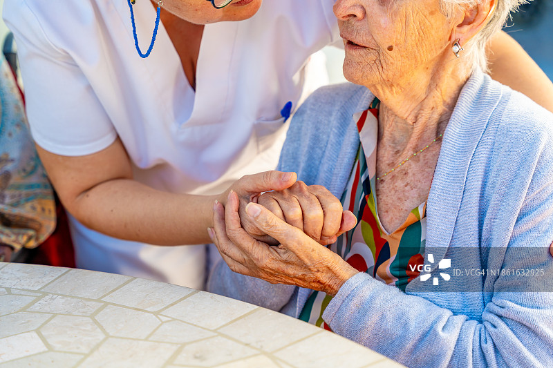 富有同情心的护士与老年人手牵着手图片素材