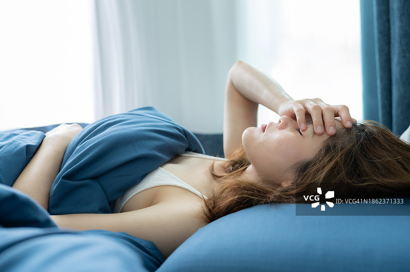 在床上休息时头痛的女人图片素材