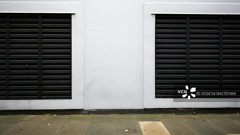 英国伦敦白色油漆混凝土墙与黑色金属通风栅图片素材