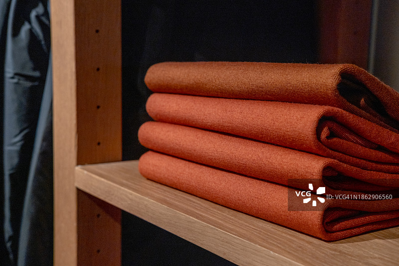 堆叠的橙色羊绒套头衫图片素材