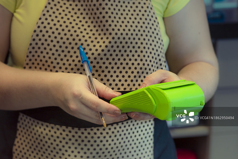 波点围裙女人用刷卡机收款图片素材