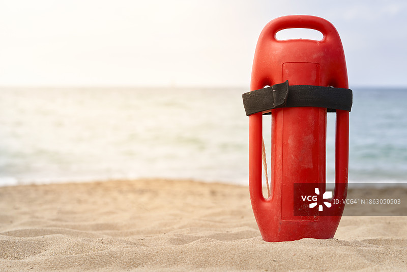 沙滩上红色救生圈的正面图，背景为大海图片素材