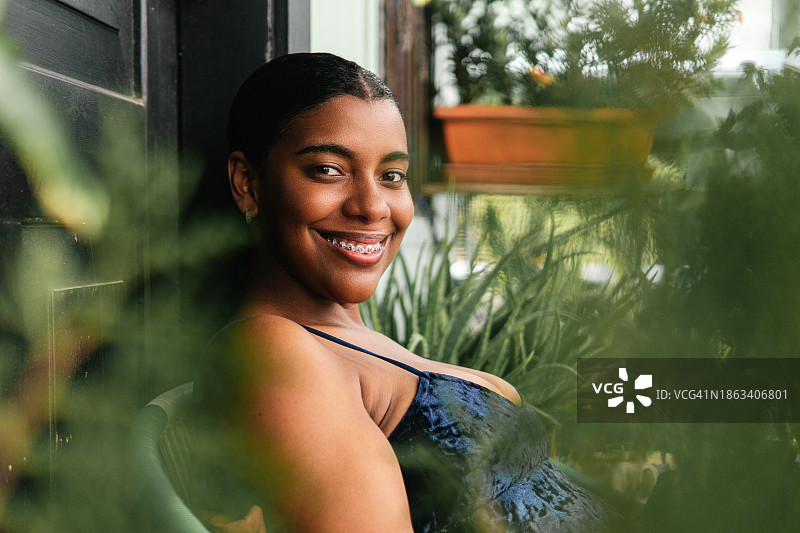 戴着支架站在椅子上的年轻加里富纳女人图片素材