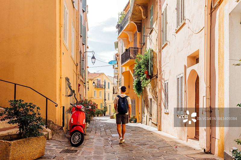 背包游客在法国戛纳老城区游览的背影图片素材