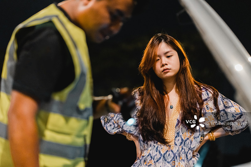 技术员在夜间露天停车场检查故障车辆图片素材