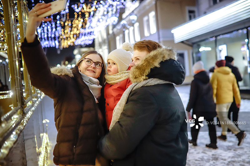 圣诞灯光下的温馨家庭自拍：珍藏欢乐冬日图片素材