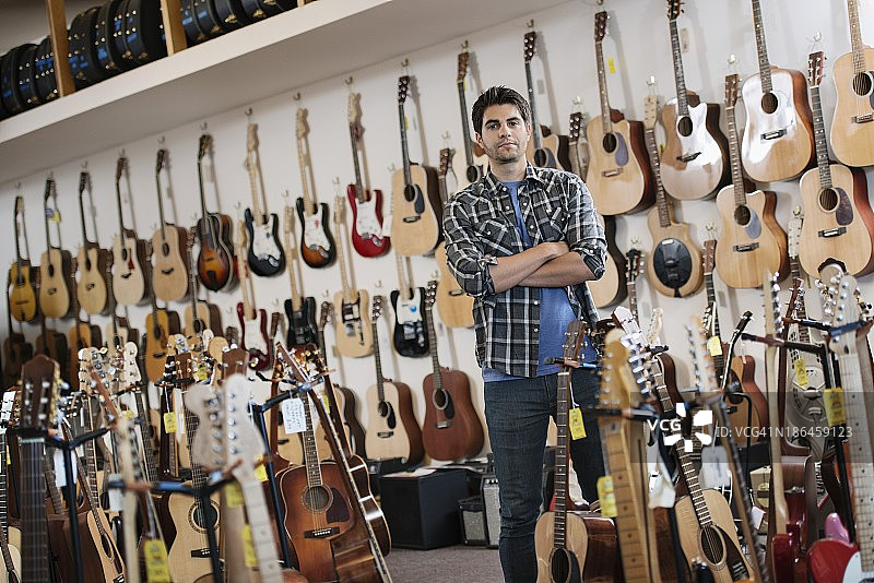 站在吉他店里的男人图片素材