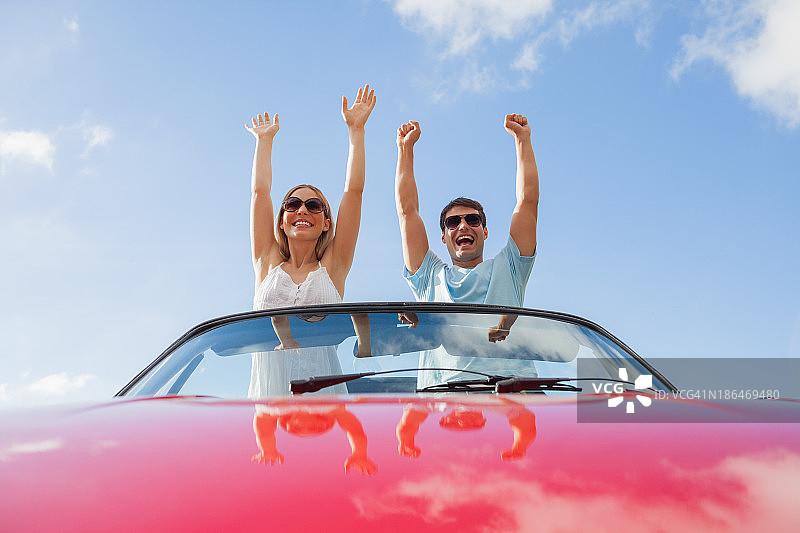 疯狂情侣站在红色敞篷车里图片素材