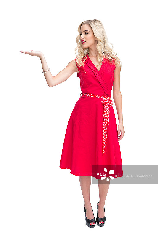 微笑的女人穿着红色连衣裙，手里拿着东西图片素材