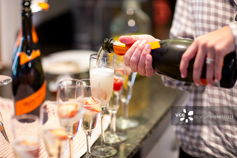 向一排玻璃杯中倒葡萄酒图片素材