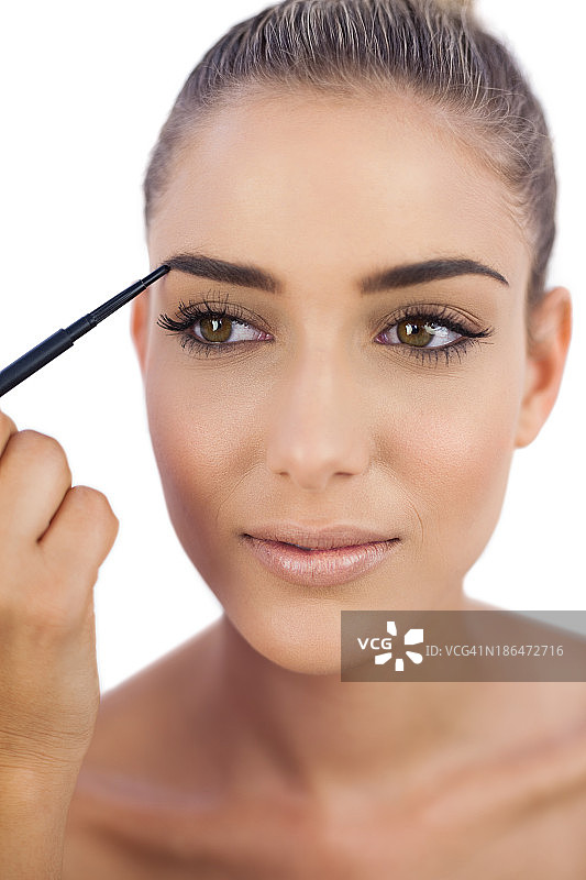 微笑的女人在画眉毛图片素材