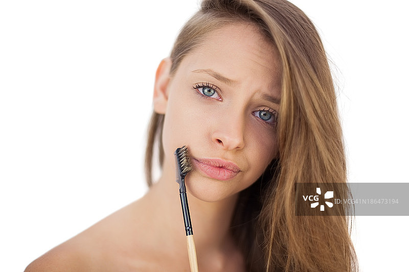 拿着刷子的困惑的黑发女模特图片素材