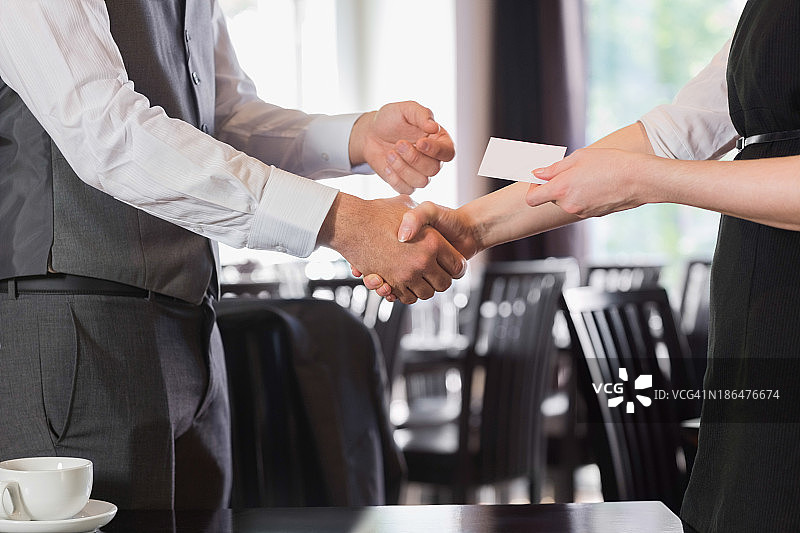 商务人士在会面后握手并互换名片图片素材