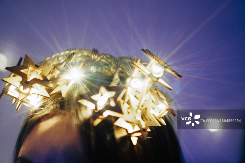 戴着星光圣诞花环的少女的肖像，悲伤地向下看。沉思、白日梦、孤独的概念图片素材