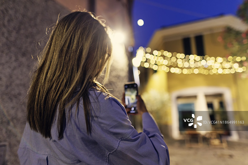 在迷人的意大利小镇夜晚观光的少女肖像图片素材