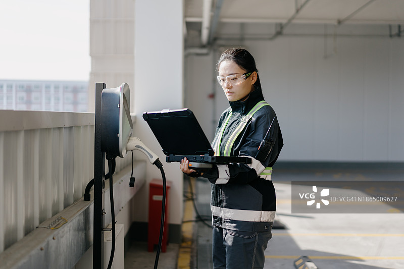 员工检查电动汽车充电站图片素材