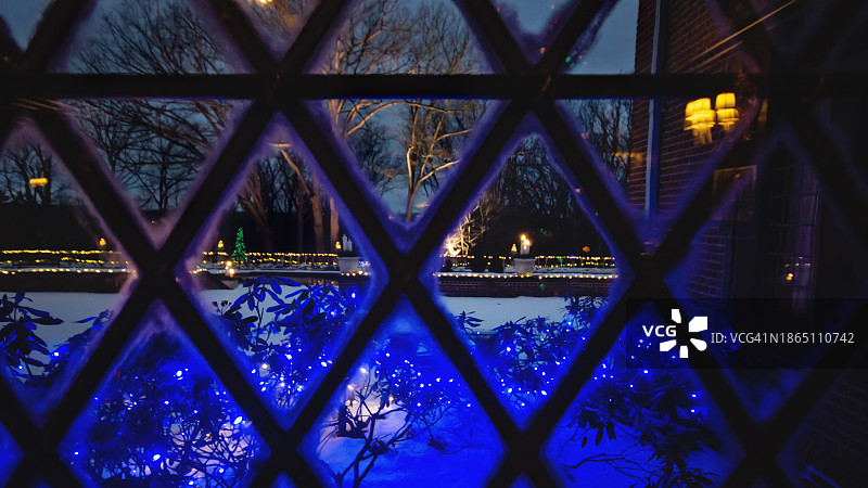 夜晚菱形窗框，带有室外圣诞灯和雪图片素材