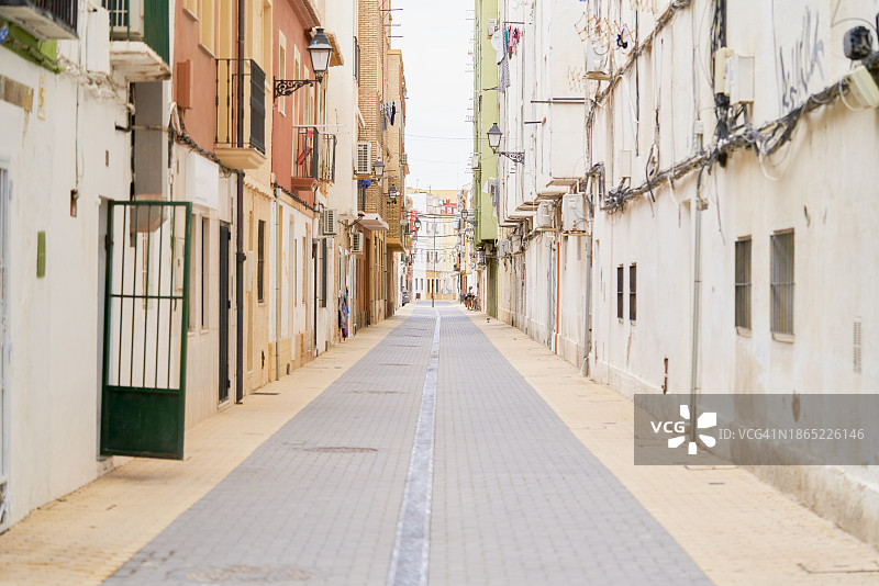 住宅区里城市中孤独的狭窄街道，白天有很多房屋图片素材