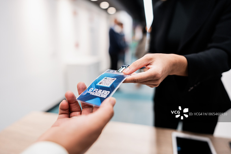 参加会议的商务人士领取徽章的特写图片素材