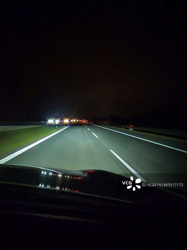夜间行驶在公路上的汽车前灯视野图片素材