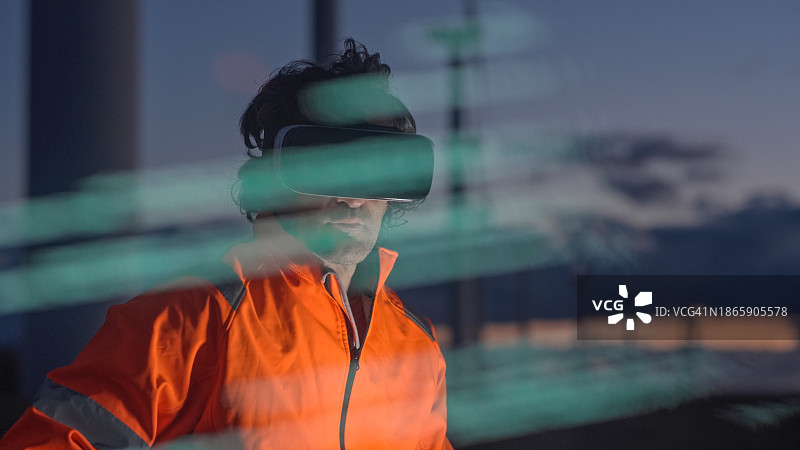 AI和VR在风力发电场中的应用。工程师使用VR眼镜和HUD全息图工作。夜班。图片素材