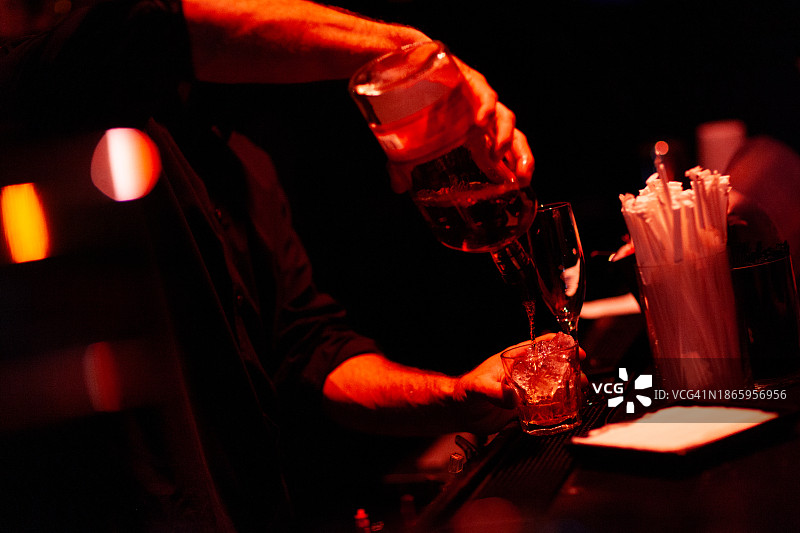酒保倒威士忌到冰块上图片素材
