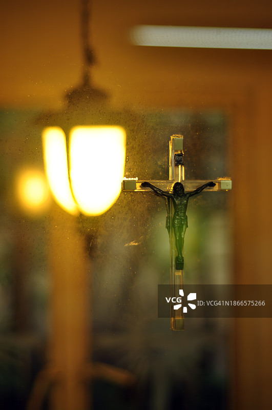 墙灯背景下的十字架竖版特写图片素材