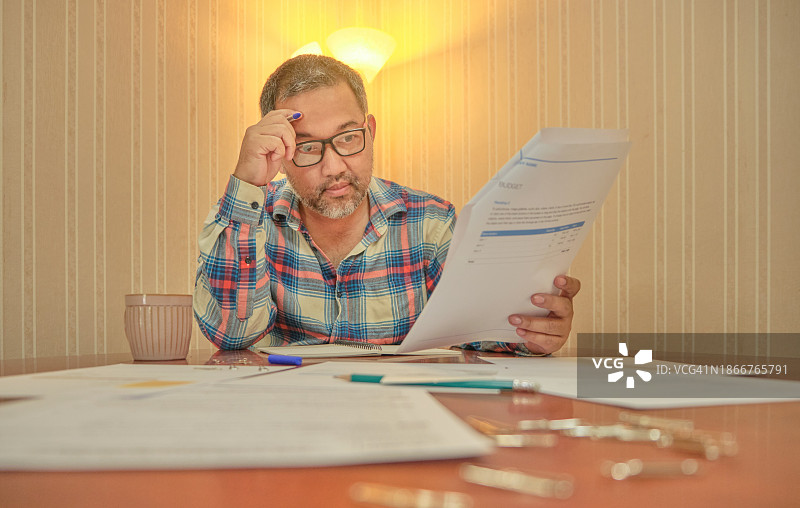 男子计划家庭财务，文件繁多图片素材