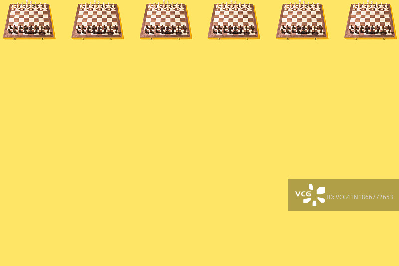 黄色背景上的木制国际象棋棋盘与棋子图案图片素材