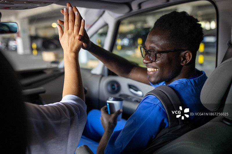 年轻男人上车并与朋友击掌图片素材